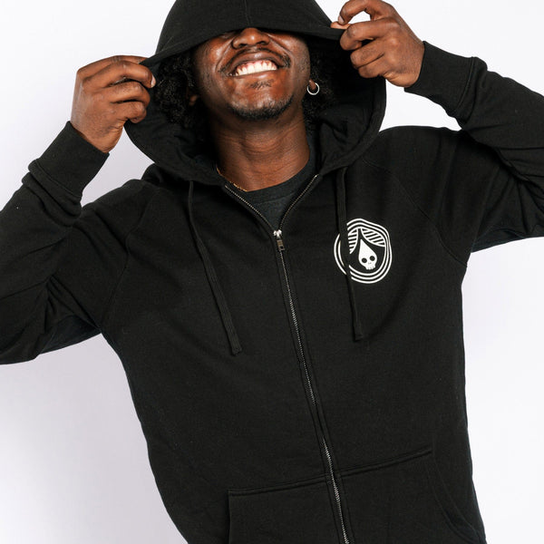 Person wearing a black hoodie with a logo on a white background